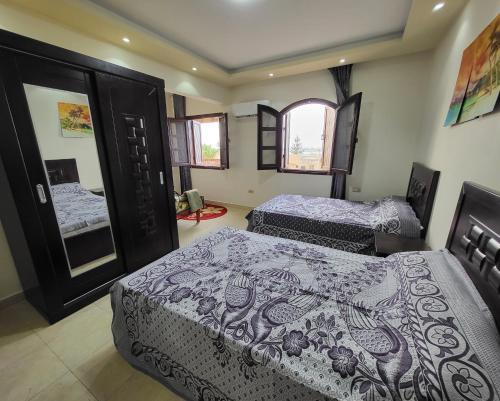 a bedroom with two beds and two windows at Lake & Sea View Duplex in Marina 2 in El Alamein