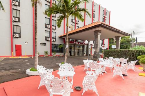 a group of white tables and chairs in front of a building at Hotel Dan Inn Araraquara by Nacional Inn in Araraquara