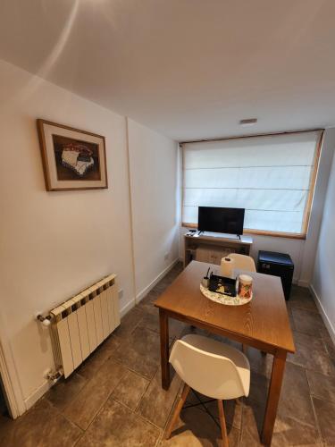 a room with a table and a desk with a computer at Mirabeagle Departamentos in Ushuaia
