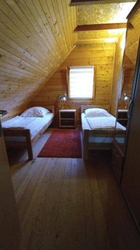 a room with two beds in a wooden cabin at Apartman Relax in Nature in Jajce