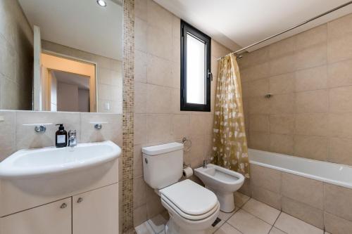 een badkamer met een toilet, een wastafel en een bad bij Viaggiato Regam in Cordoba
