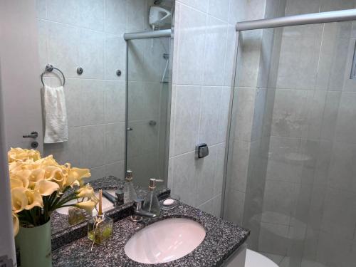 a bathroom with a sink and a shower at Aconchegante Apartamento decorado e mobiliado in Cascavel