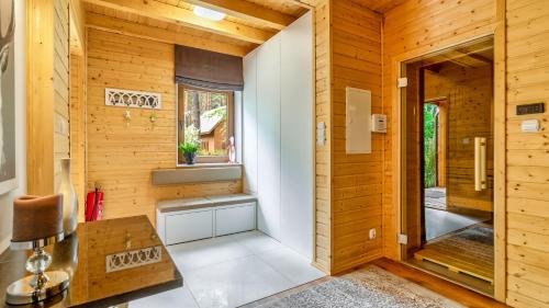 Habitación pequeña con paredes de madera y ventana. en Leśna Oaza, en Ostróda