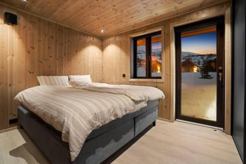 a bedroom with a bed and a large window at Tonningssætra Mountain Lodge in Stryn