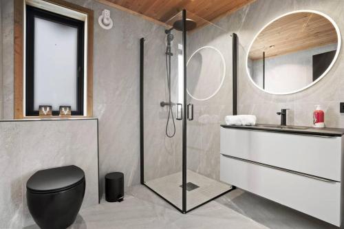 a bathroom with a shower and a toilet and a sink at Tonningssætra Mountain Lodge in Stryn