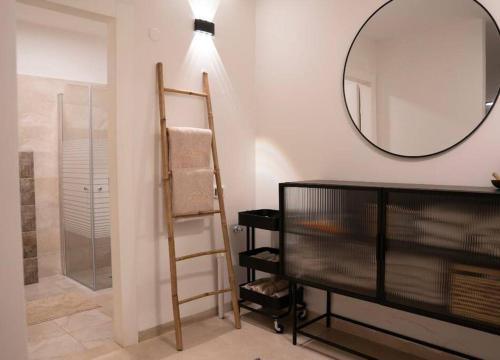 een badkamer met een ladder, een spiegel en een douche bij Migdalor in Migdal