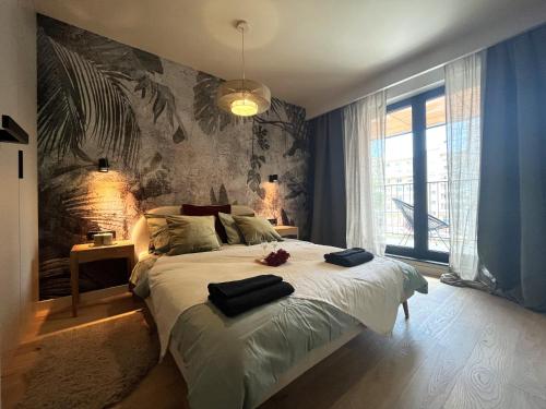 a bedroom with a large bed with two towels on it at WYSZYŃSKIEGO Apartment - Self Check-In 20h - Parking &Lift in Wrocław