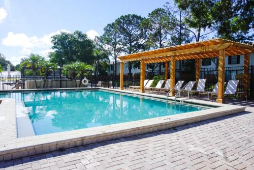 una piscina con cenador y sillas en Boho Tampa Townhouse - Pool, Gym, Arcade, en Tampa
