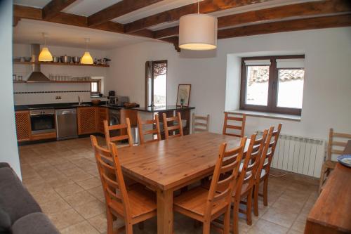 eine Küche und ein Esszimmer mit einem Holztisch und Stühlen in der Unterkunft vivienda turistica EL PATIO in Saucelle