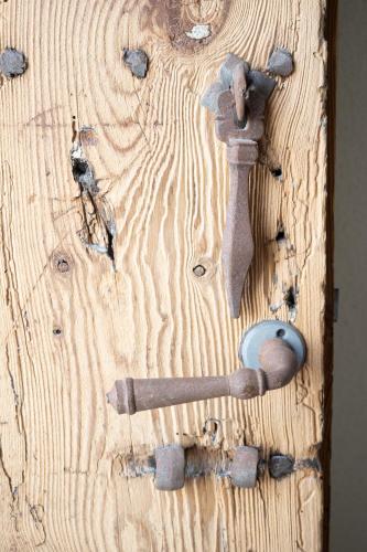 a wooden door with a hammer and a wrench on it at Apartamentos Alcoba 13 in Sanlúcar de Barrameda