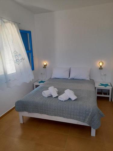 a bedroom with a bed with two towels on it at Το Κυμα . in Livadi Astypalaias