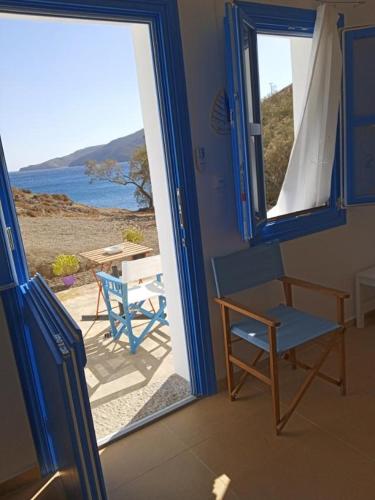 a room with a door open to a patio with a table and chairs at Το Κυμα . in Livadi Astypalaias