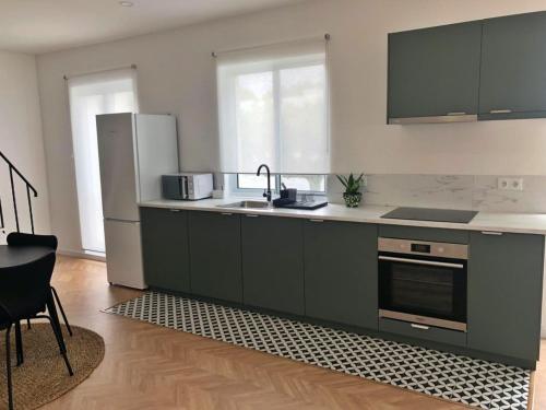 a kitchen with a sink and a refrigerator at Charme do Largo - Apartamento in Lagoa