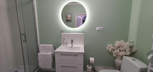 a bathroom with a sink and a mirror and a toilet at Mieszkanie z 2 sypialniami i pokojem gier in Borne Sulinowo