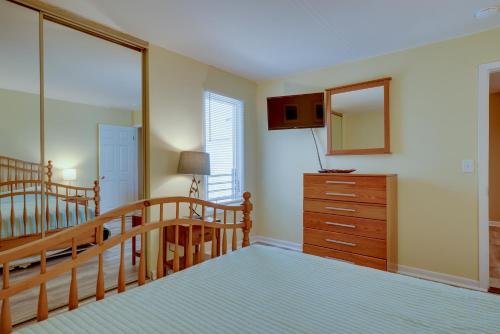 a bedroom with a staircase and a dresser with a mirror at Seaside Heights Condo with Deck Walk to Boardwalk! in Seaside Heights