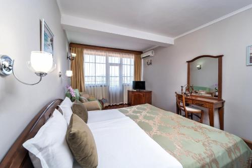 um quarto com uma cama e uma secretária em Hotel Izvora em Kranevo
