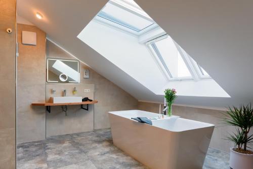 a bathroom with a sink and a skylight at Hotel Schluister Park in Carolinensiel