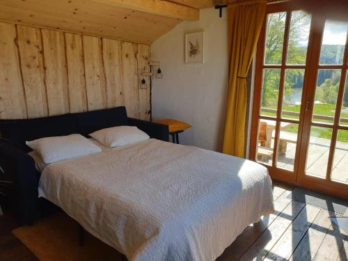 ein Schlafzimmer mit einem Bett und einem großen Fenster in der Unterkunft Ladybug Eco House 