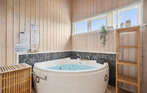 y baño con bañera y paredes de madera. en Gorgeous Home In Tarm With Kitchen, en Hemmet