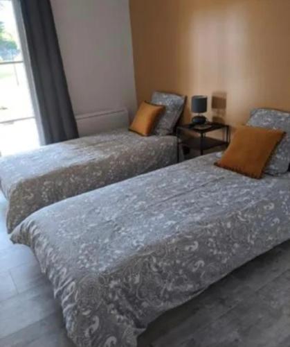 two beds sitting next to each other in a room at Maison 5 personnes in Mansigné