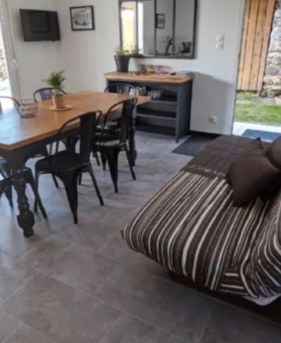 un salon avec une table et des chaises et un lit dans l'établissement Maison 5 personnes, à Mansigné