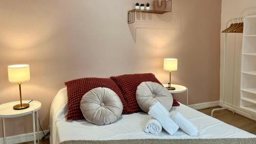 una camera da letto con un letto con cuscini e due lampade di Un goût de liberté a Nevers