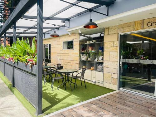 un patio con mesa y sillas fuera de un restaurante en Hotel Boutique Laureles Medellin (HBL) en Medellín