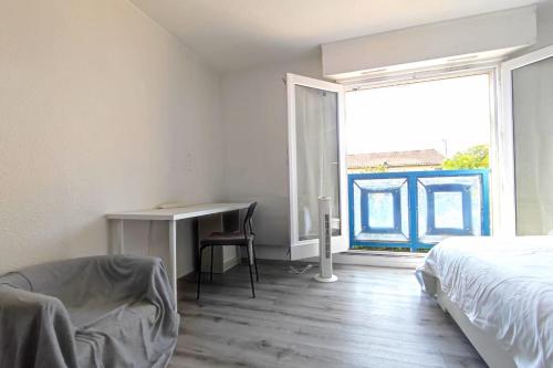 une chambre avec un lit, un bureau et une fenêtre dans l'établissement 24 m2 studio with rooftop view, à Bordeaux