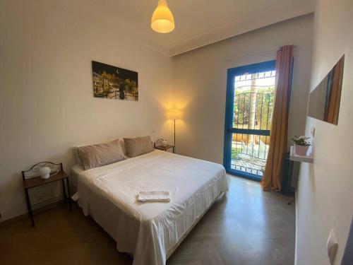 a bedroom with a white bed and a window at Séjour sable et mer: Jardin privé, Plage à 2 pas in Skhirat