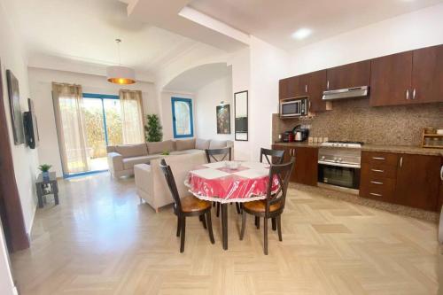 cocina y sala de estar con mesa y sillas en Séjour sable et mer: Jardin privé, Plage à 2 pas en Skhirat