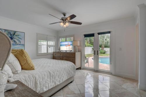 a bedroom with a bed and a ceiling fan at Pool Home Super Close To Vanderbilt Beach in Naples