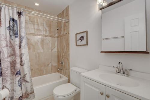 a white bathroom with a toilet and a sink at Pool Home Super Close To Vanderbilt Beach in Naples