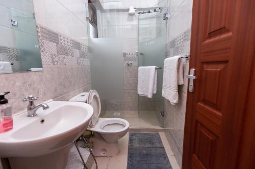 y baño con lavabo, aseo y ducha. en Luxurious-2 bedroom Furnished Apartment, en Nairobi