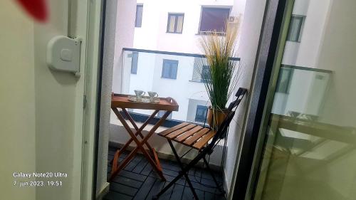a table and a chair on a balcony with a window at RELAX LUX AKVA PARK 2(K-KOMPLEX) in Jagodina