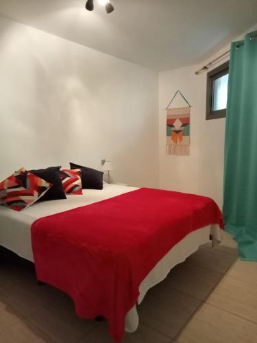 una camera da letto con un grande letto con una coperta rossa di Puntillo I 302 a Santa Cruz de Tenerife