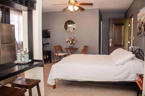 a bedroom with a white bed and a table and chairs at Cozy Guest Studio Apartment in Downtown Boquete in Boquete