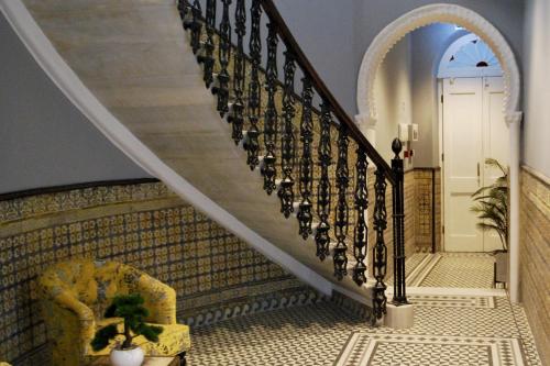 a staircase in a house with a chair and a door at Delightful City Centre Studio Clarendon Apartment - Grand Central House in Gibraltar