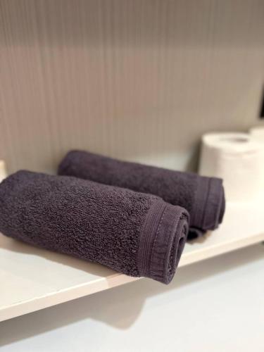 two rolls of purple towels sitting on a shelf at Top Apartment In The Centre Of Warsaw, Wi-Fi - by HIK Apartments in Warsaw