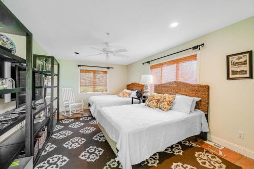 a bedroom with two beds and a tv in it at Meadow Beauty in Westhampton Beach