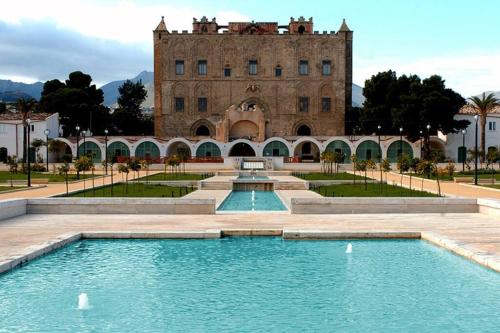 a building with a swimming pool in front of a building at Zisa House Casa Vacanze in Palermo