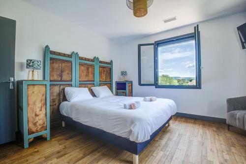 une chambre avec un grand lit et une fenêtre dans l'établissement COMBE JOLIE Clim, Piscine & Jacuzzi, à Saint-Vincent-de-Cosse