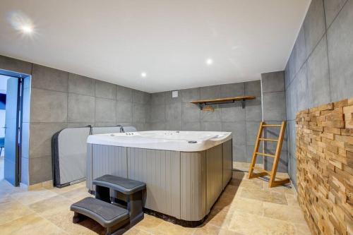 La salle de bains est pourvue d'une baignoire et d'une échelle. dans l'établissement COMBE JOLIE Clim, Piscine & Jacuzzi, à Saint-Vincent-de-Cosse