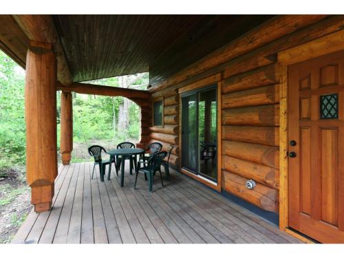 a porch of a log cabin with a table and chairs at Karuizawa Sunny Village - Vacation STAY 57953v in Karuizawa