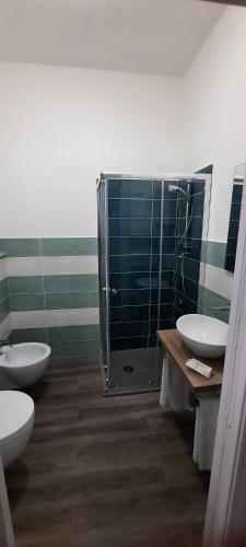 a bathroom with two sinks and a shower and two toilets at La Llua Alghero in Alghero
