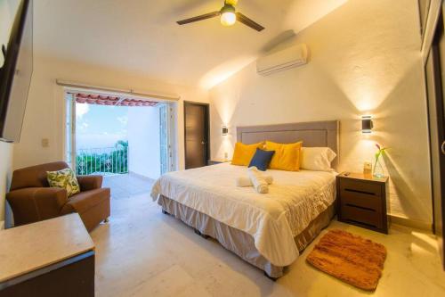 a bedroom with a bed and a couch and a window at Casa María Con Alberca Privada in Puerto Vallarta