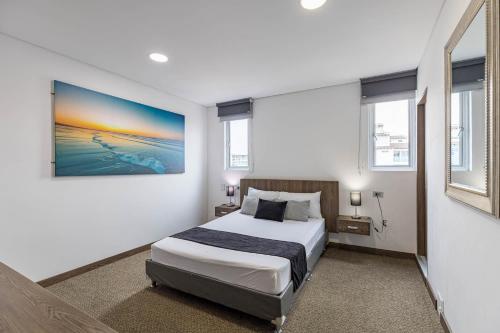a bedroom with a bed and a painting on the wall at Hotel Velero in San Antonio de Pereira