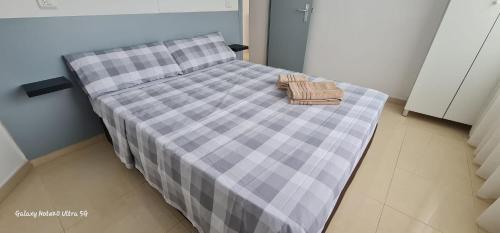 a bed with a checkered blanket and a basket on it at PISO CALPE - 2º LINEA in Calpe