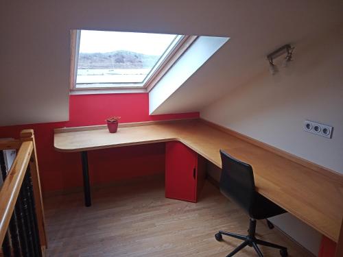 an attic room with a desk and a window at Apartamento La Riberuca in Suances