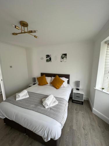 a bedroom with a large bed with yellow pillows at 3 bed luxury open plan living in Rayleigh