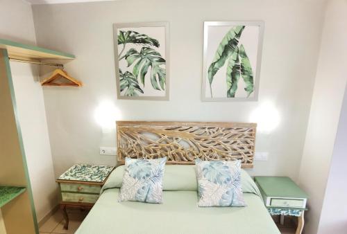 Schlafzimmer mit einem Bett mit blauen und weißen Kissen in der Unterkunft HOSTAL RIGAU in Sant Feliu de Guixols